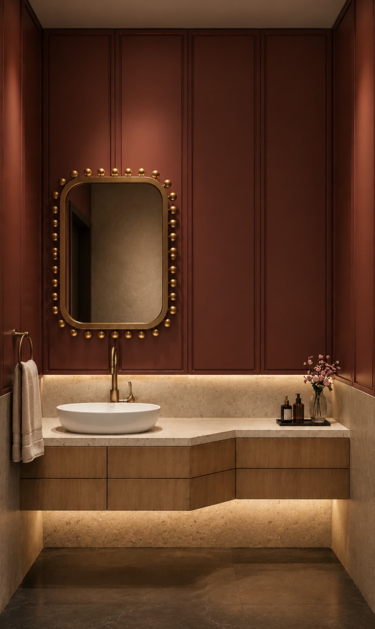 Powder room with deep red panelled walls and a brass bobbin-framed mirror
